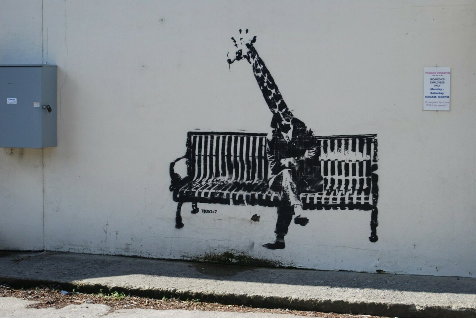 Banksy Giraffe sitting on a bench